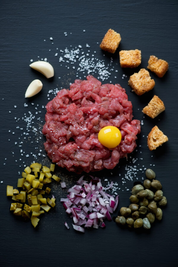Beef tartar with yolk, pickles, onion, capers and croutons
